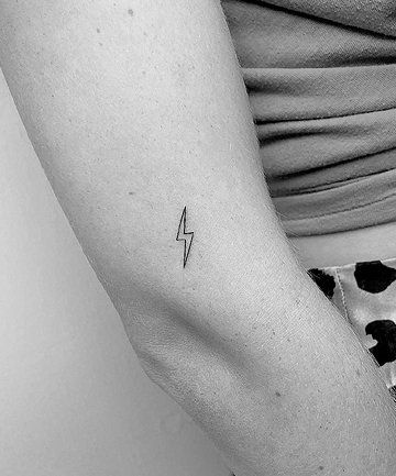 a woman's arm with a small lightning tattoo on the left side of her arm