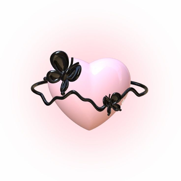 a pink heart with black balloons attached to it