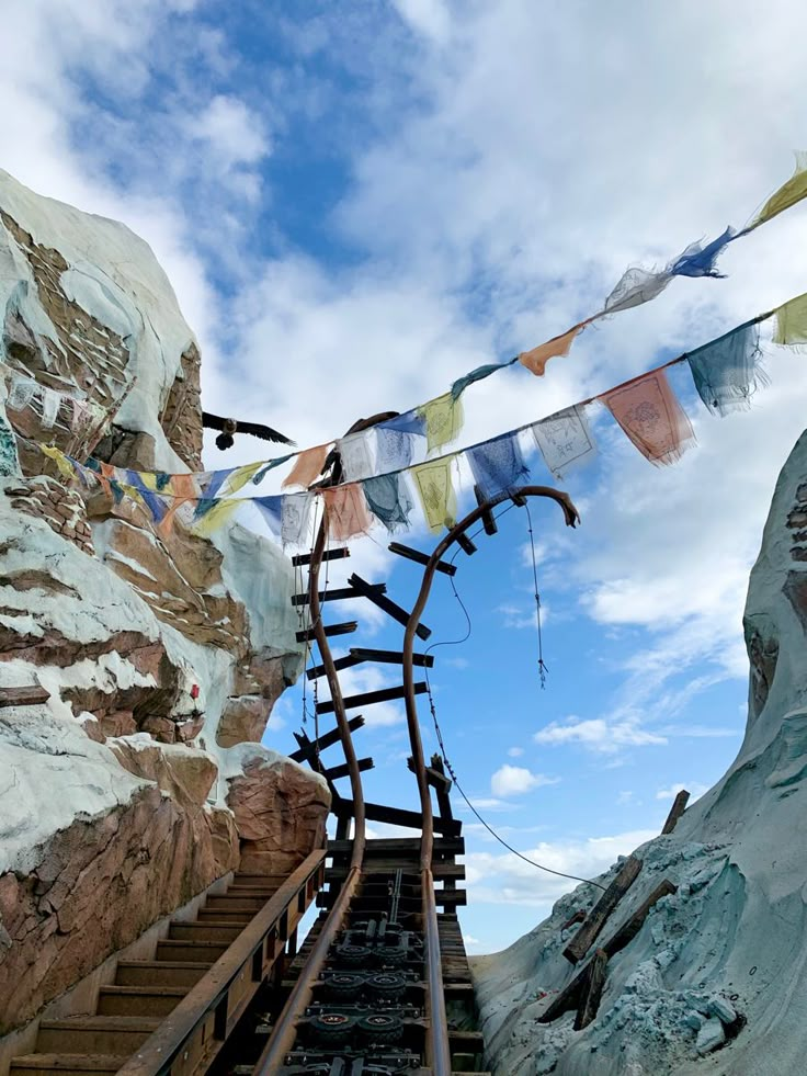 there is a set of stairs going up to the top of a mountain with flags