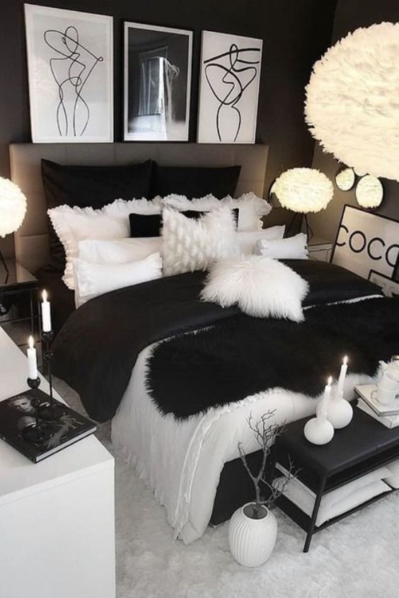 a black and white bedroom with candles on the nightstands in front of the bed