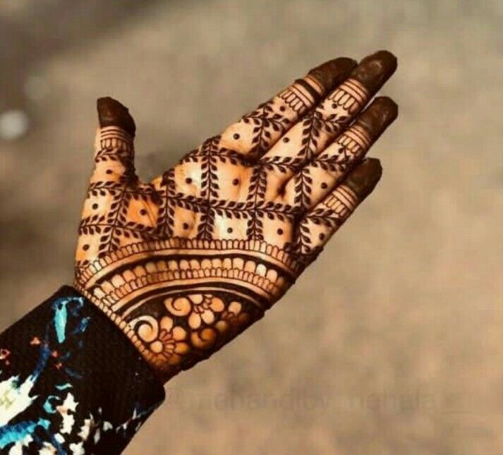 a close up of a person's hand with henna tattoos