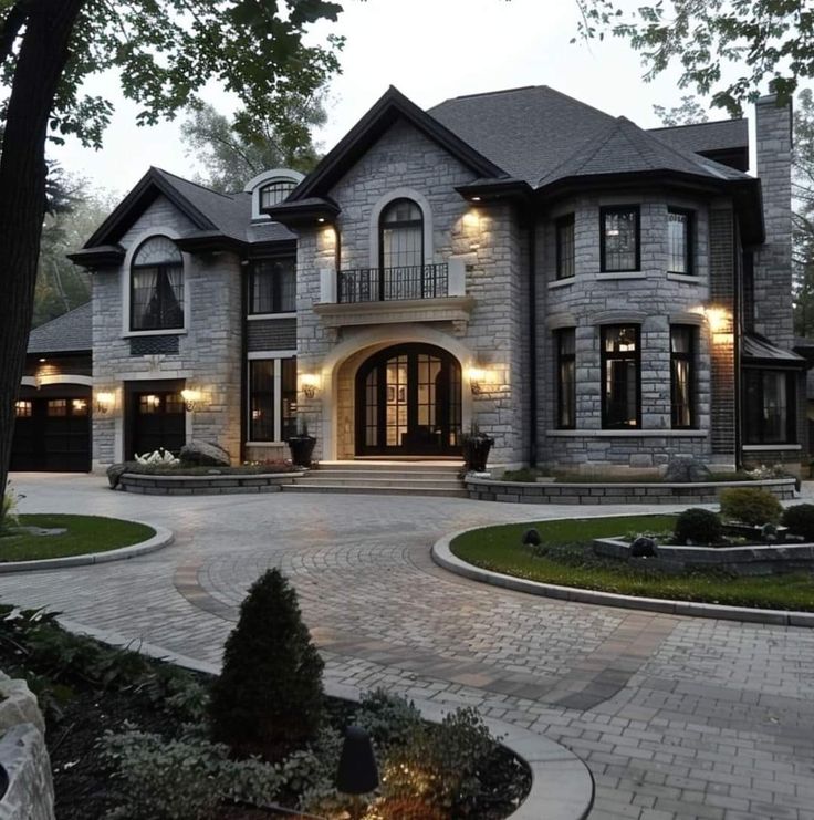 a large house with lots of windows and lights on it's front entrance area