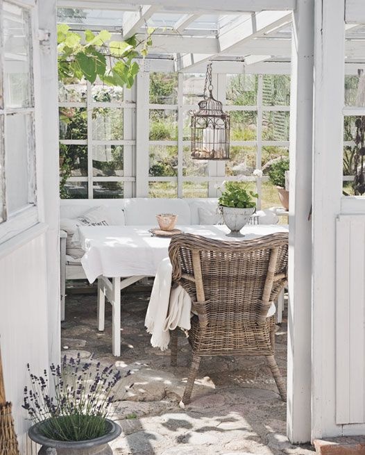 an outdoor dining area with wicker furniture and white table cloths on the tables