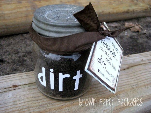 a jar filled with dirt sitting on top of a wooden bench next to a tag