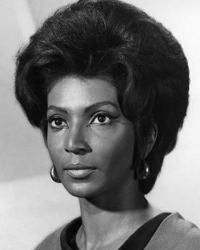 an old black and white photo of a woman with short hair wearing a sweater over her shoulder