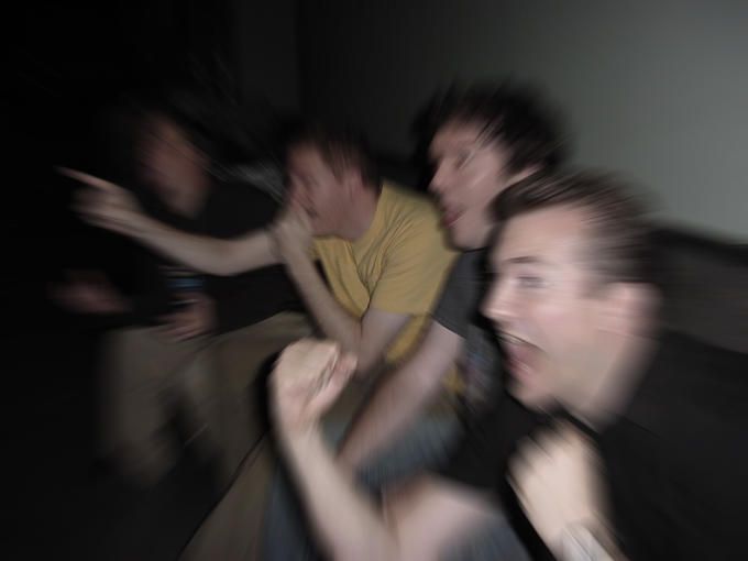 blurry photograph of four people sitting on a couch with their arms around each other