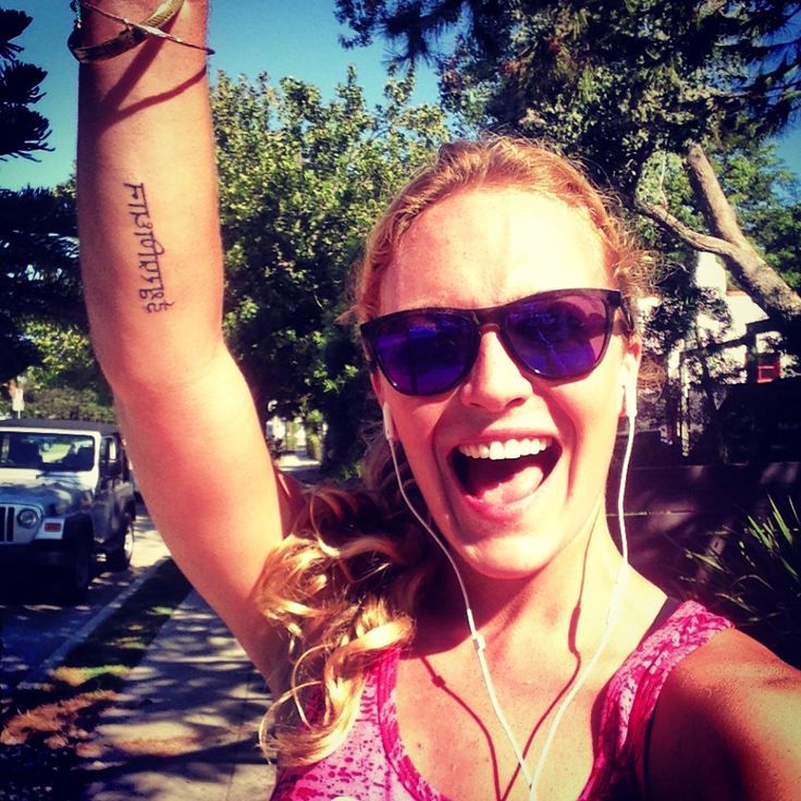 a woman wearing sunglasses and headphones holding up her arm