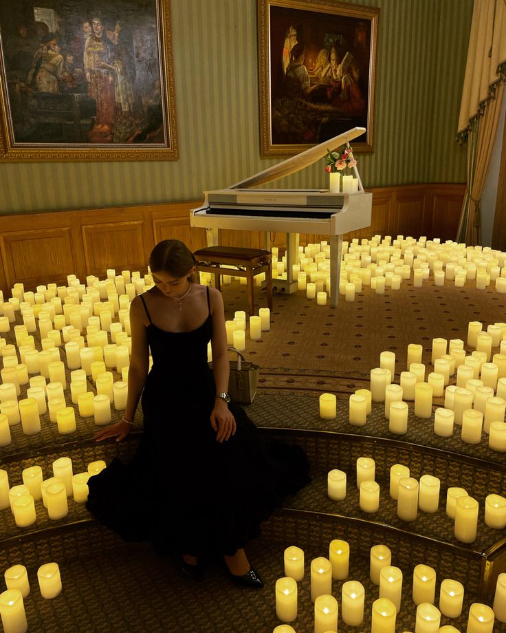 a woman sitting on the floor surrounded by candles