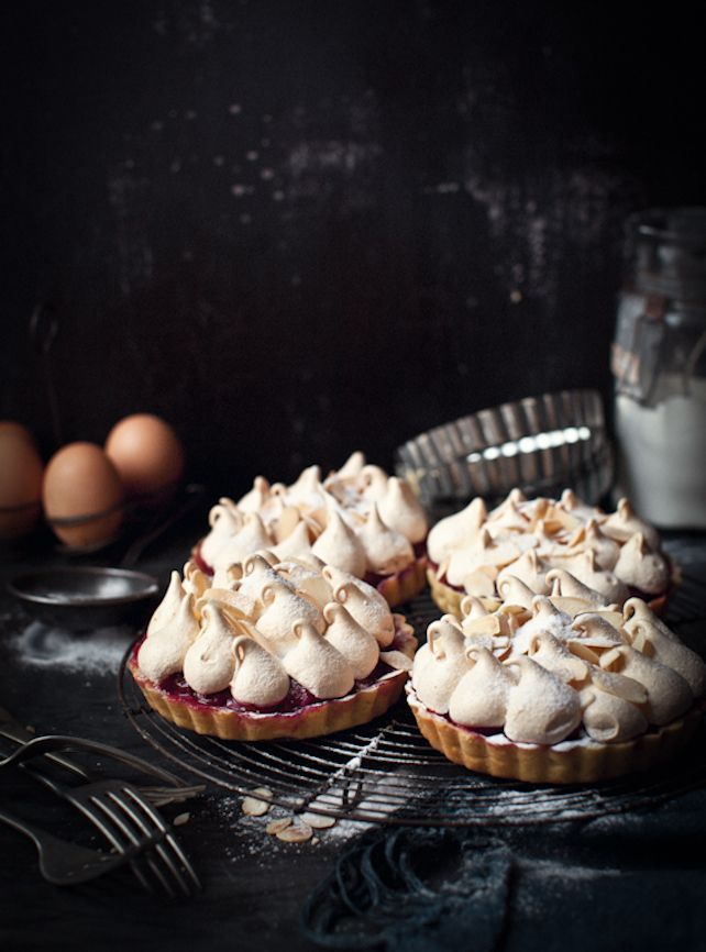 three pies on a cooling rack with eggs in the back ground and two forks next to them