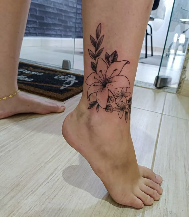 a woman's foot with a flower tattoo on her left ankle and the bottom part of her leg