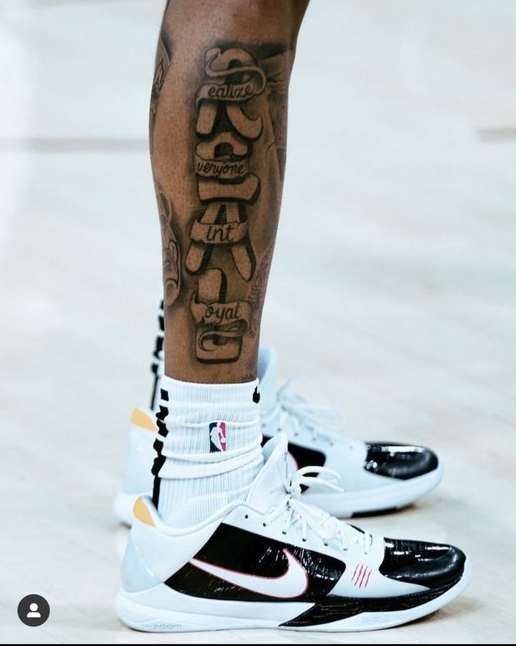 a person with tattoos on their legs and sneakers