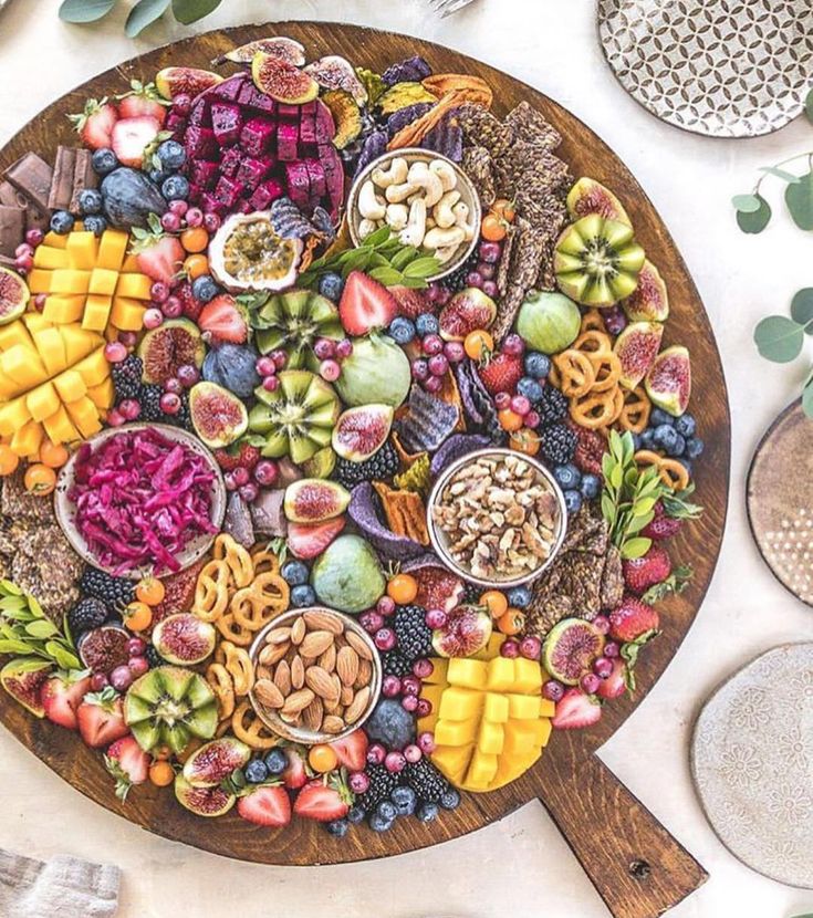 a platter filled with lots of different types of fruits and vegetables on top of a table