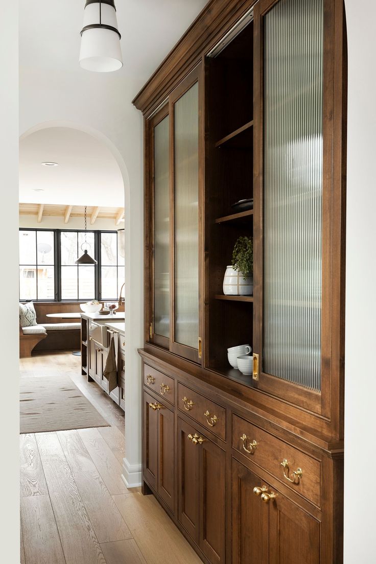 a wooden cabinet with glass doors in a room