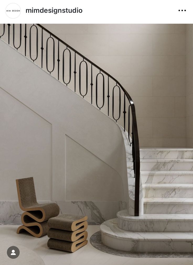 an image of a stair case in the middle of a room with marble steps and chairs