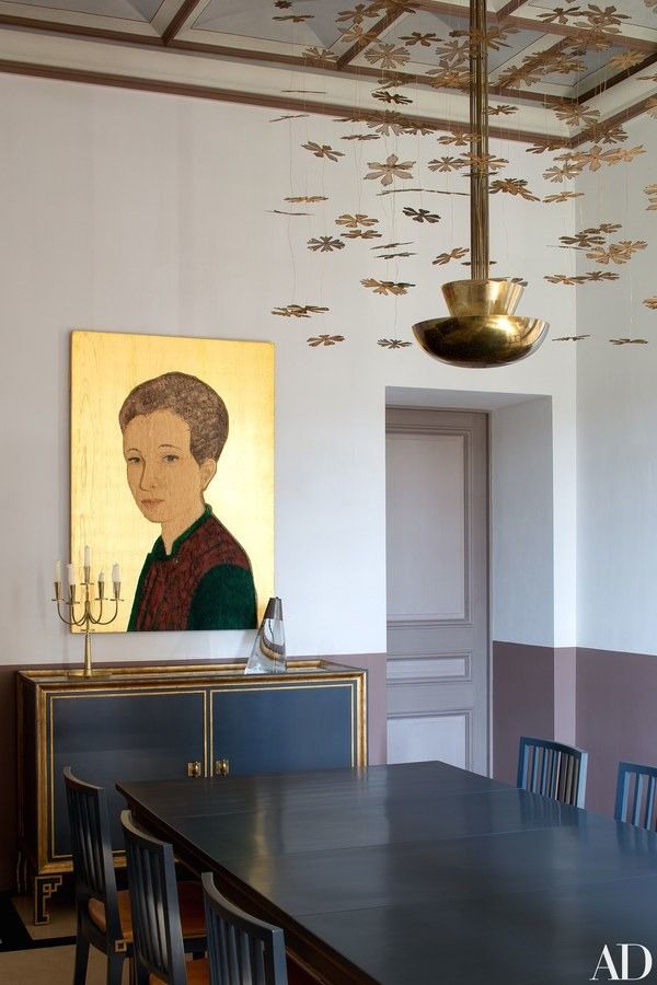 a dining room table with chairs and a painting on the wall