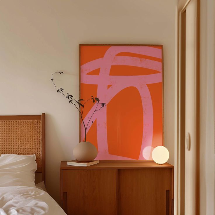 a bedroom with an orange painting on the wall