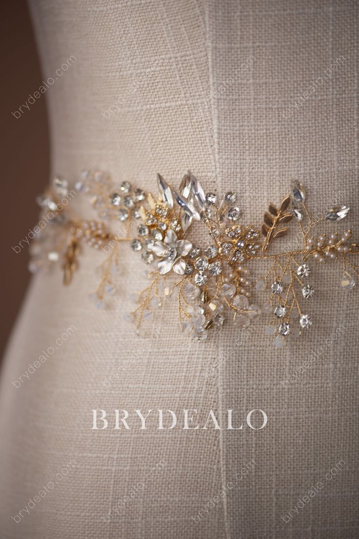 This gorgeous bridal sash belt online features a gold branch dotted with shiny crystals, delicate alloy flowers, small beads and nice pearls. Wear it with a simple silhouette or embroidered wedding dress. shown ribbon color champagne content pearl ribbon alloy bead rhinestone flower crystal embellished portion length 41cm, width 6.5cm ribbon length 100cm, width 1cm Gold Beaded Bridal Accessories For Wedding, Gold Embellished Wedding Sash, Gold Embellished Sashes For Wedding, Elegant Gold Bridal Belt For Bridesmaids, Elegant Gold Bridal Accessories With Sashes, Elegant Gold Bridal Belt With Sashes, Elegant Gold Bridal Belt, Elegant Gold Bridal Belt For Bride, Bridal Accessories Belt