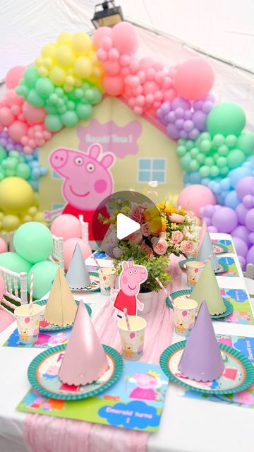 a table set up with peppa pig party decorations and balloons in the shape of a house