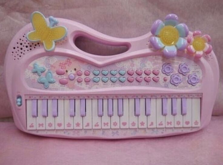 a pink toy piano with flowers and butterflies on it