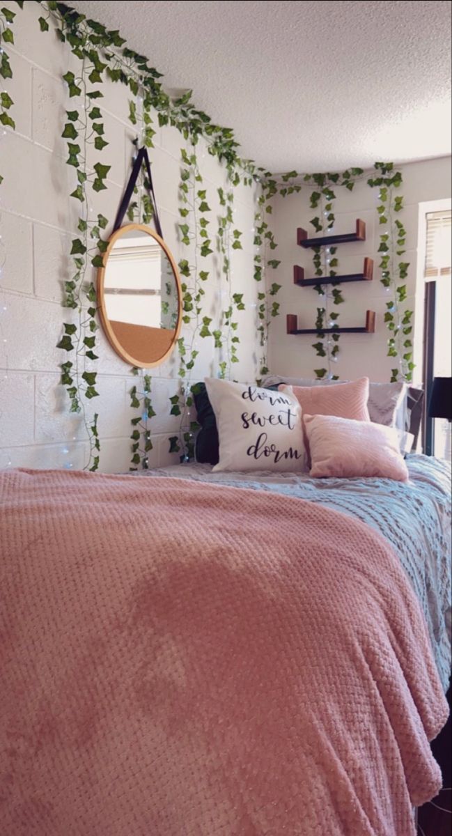 a bedroom with pink bedding and ivy on the wall