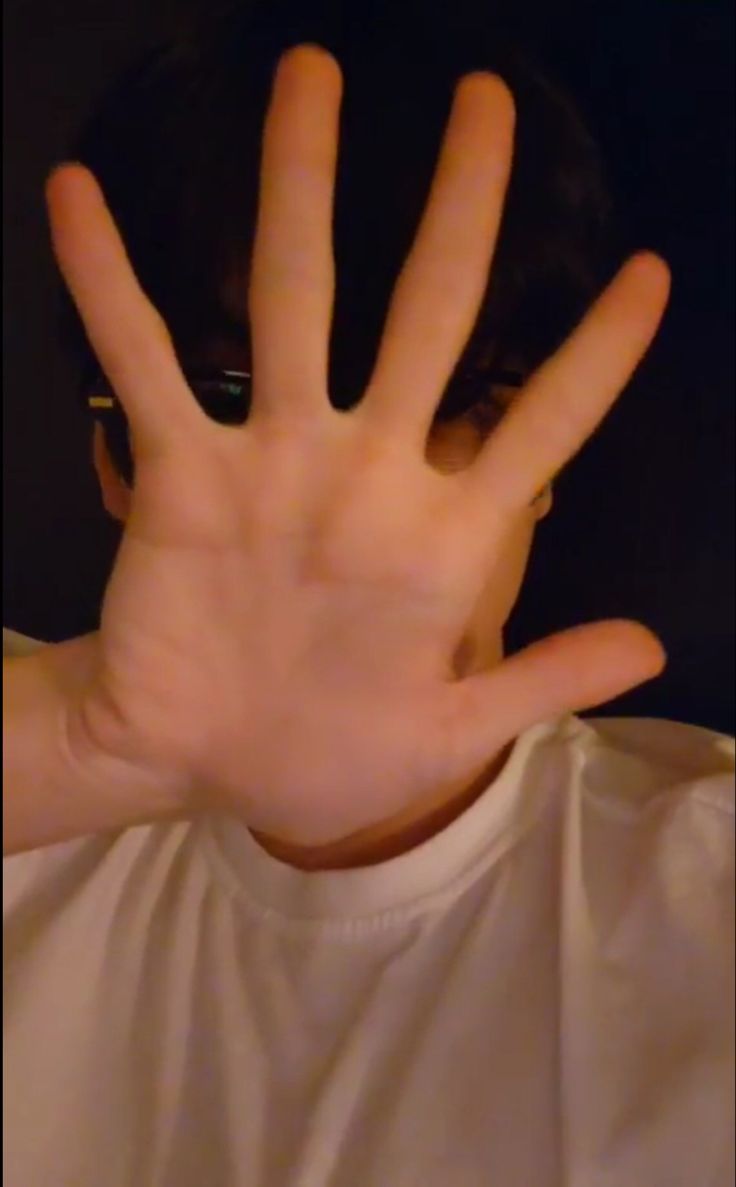 a person with their hand in the air and his face obscured by it's hands