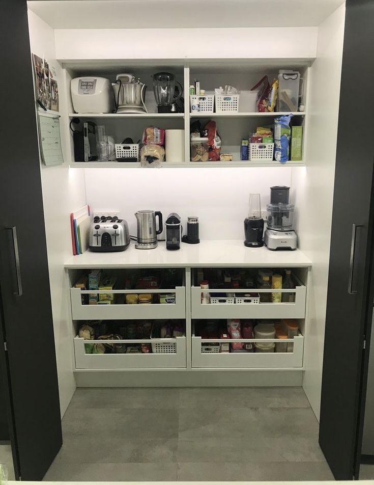 an organized pantry with coffee machines and other items