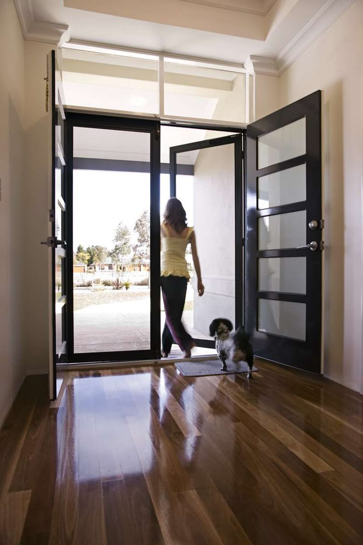 a woman is walking her dog through the door