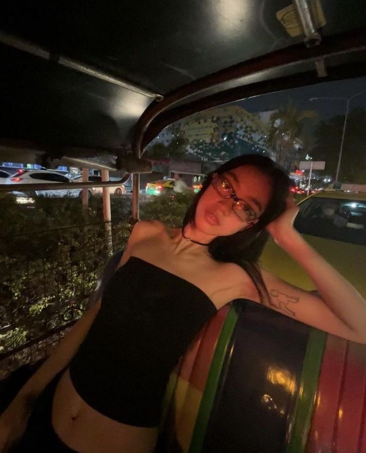 a woman sitting in the back of a car at night