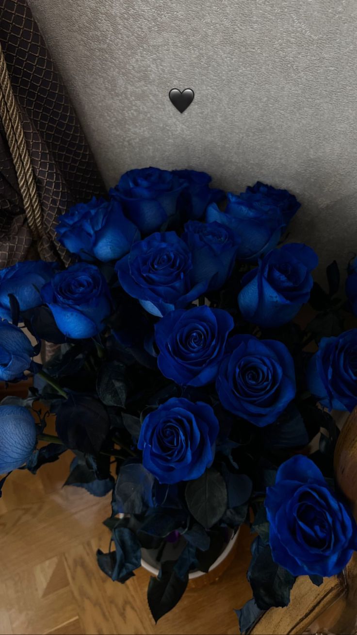 a bouquet of blue roses sitting on top of a wooden table next to a chair