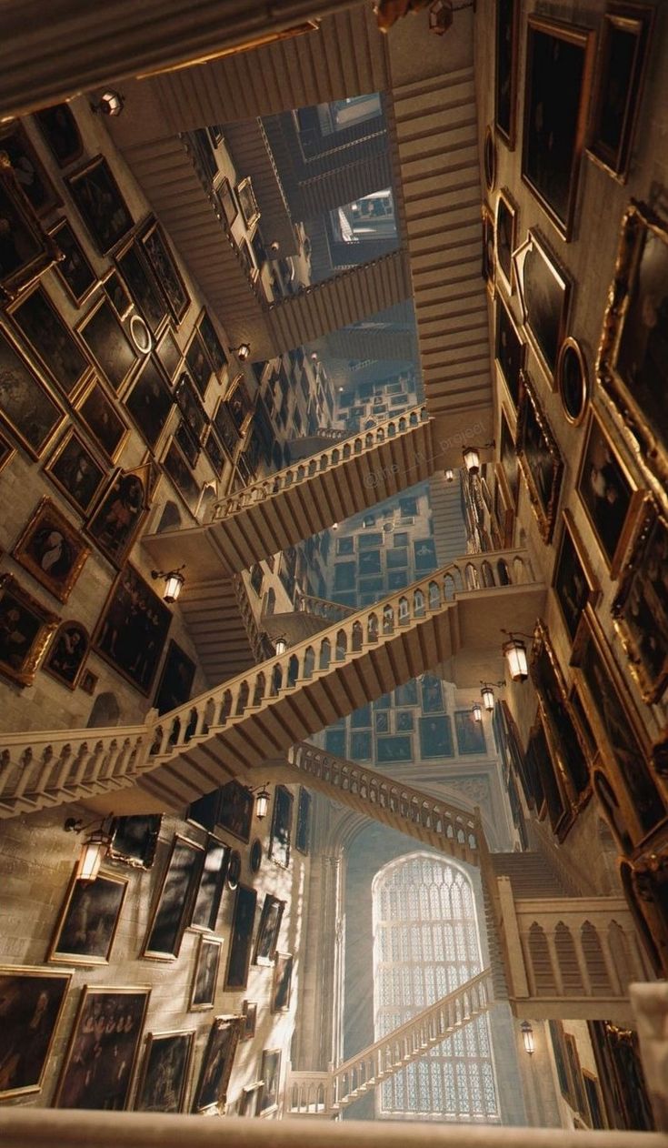 the inside of a building with multiple staircases and pictures on the wall above it