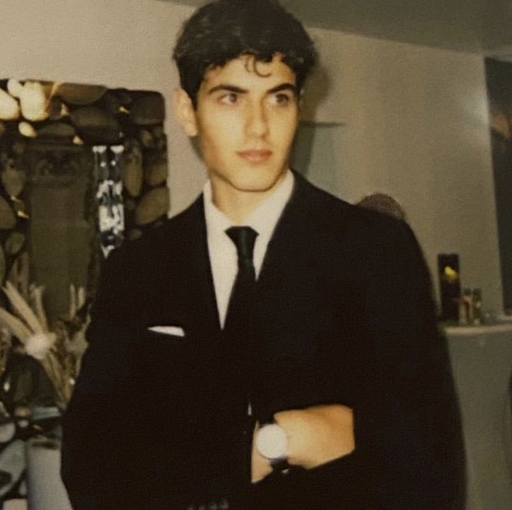 a young man wearing a suit and tie