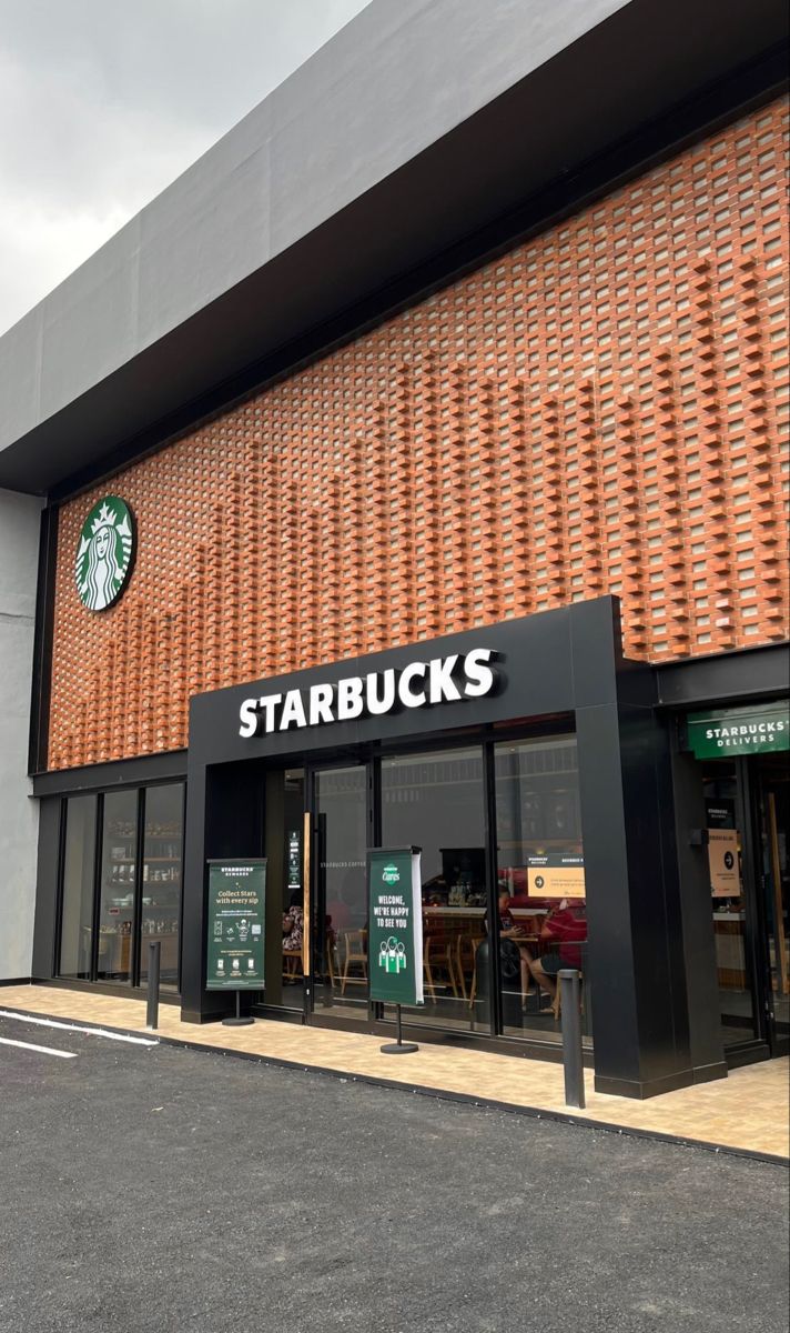 the starbucks store is located in front of an orange brick building