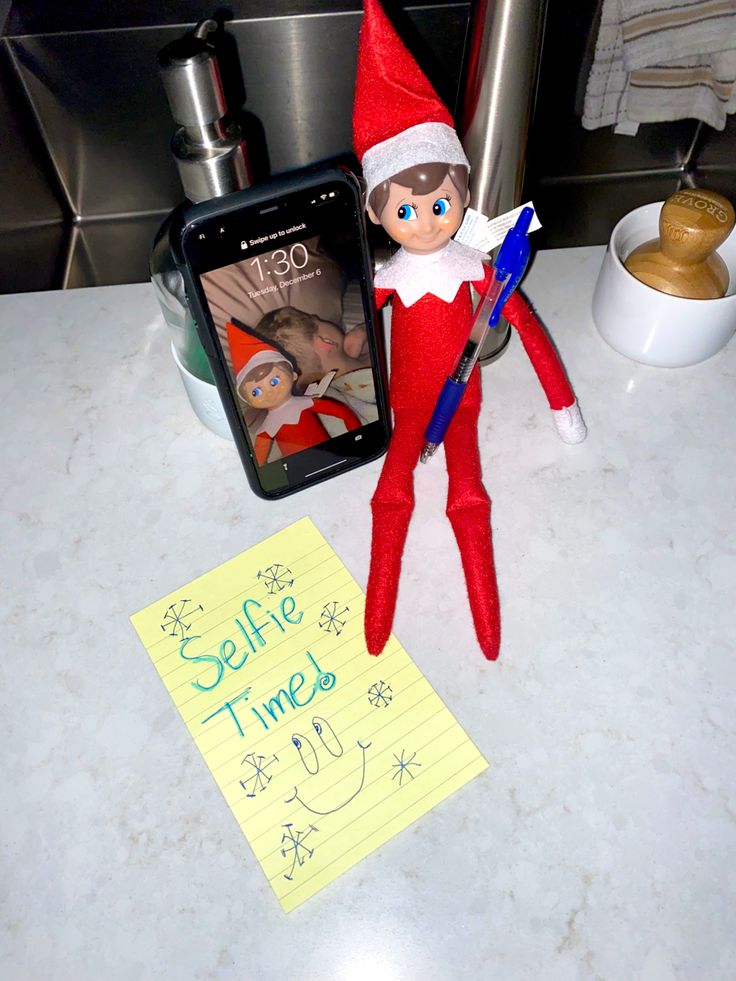 an elf with a note and cell phone next to it