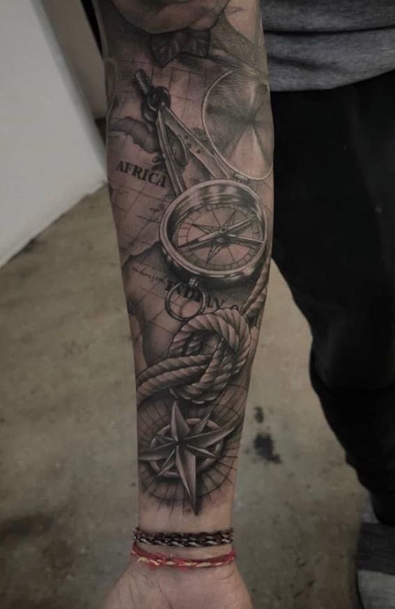 a man with a compass tattoo on his arm