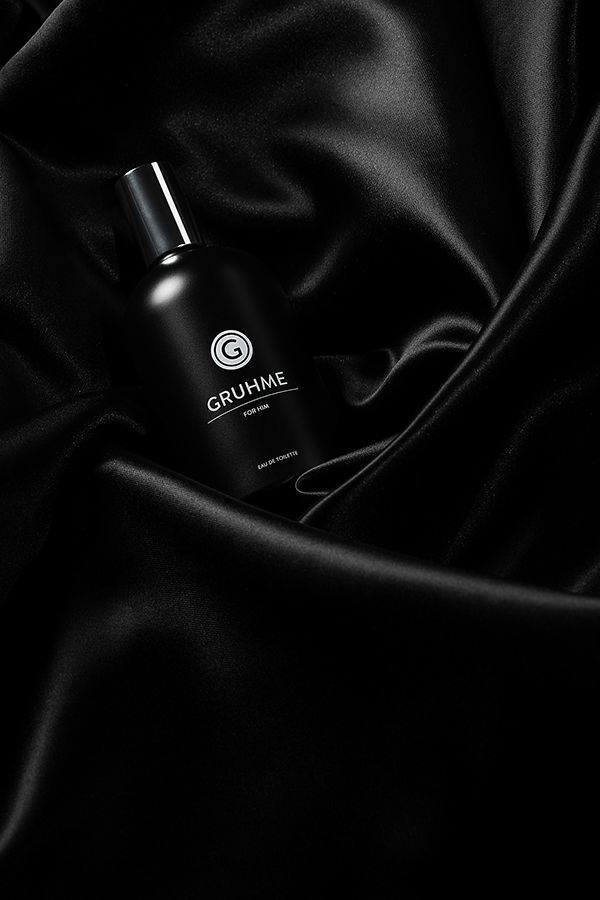 a bottle of perfume sitting on top of a black cloth with the word gruhme written