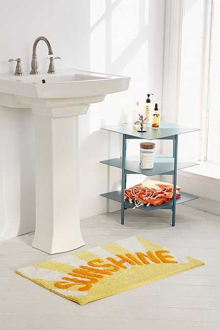 a bathroom with a sink, mirror and towel on the floor