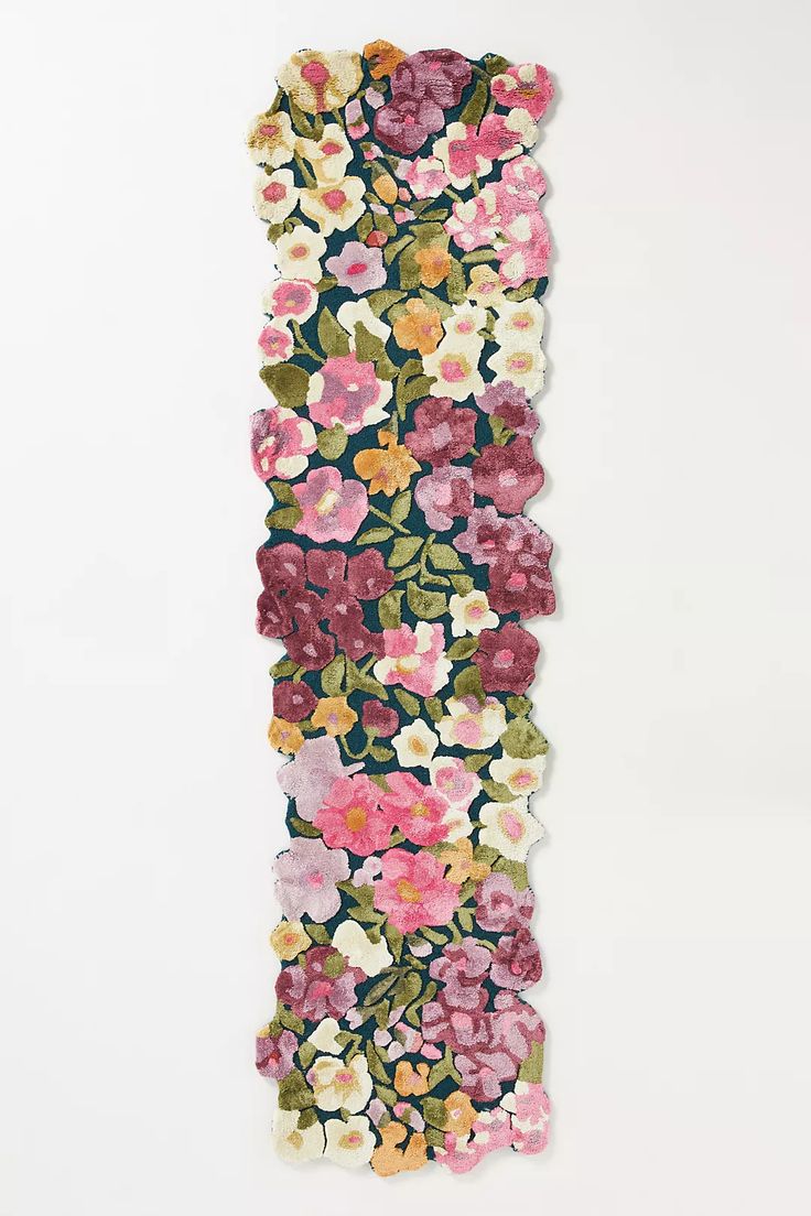 a flowered wall hanging on the side of a white wall