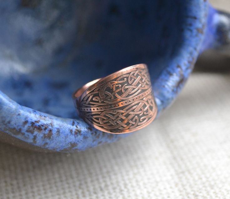 a copper ring sitting on top of a blue bowl