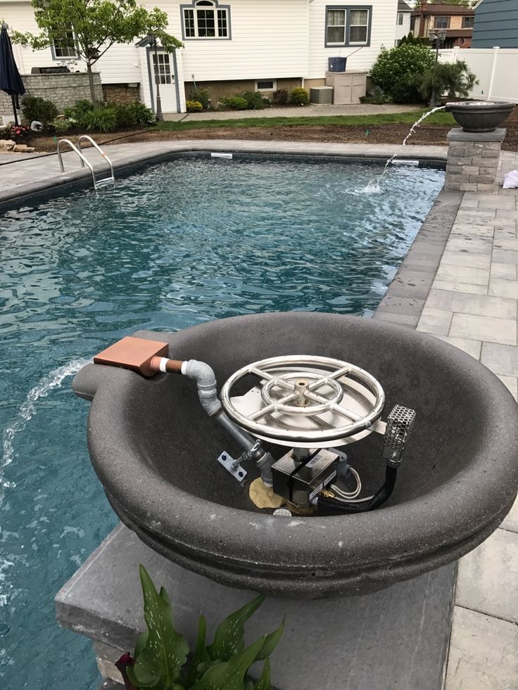 an above ground swimming pool with a hose connected to the water pump and some plants