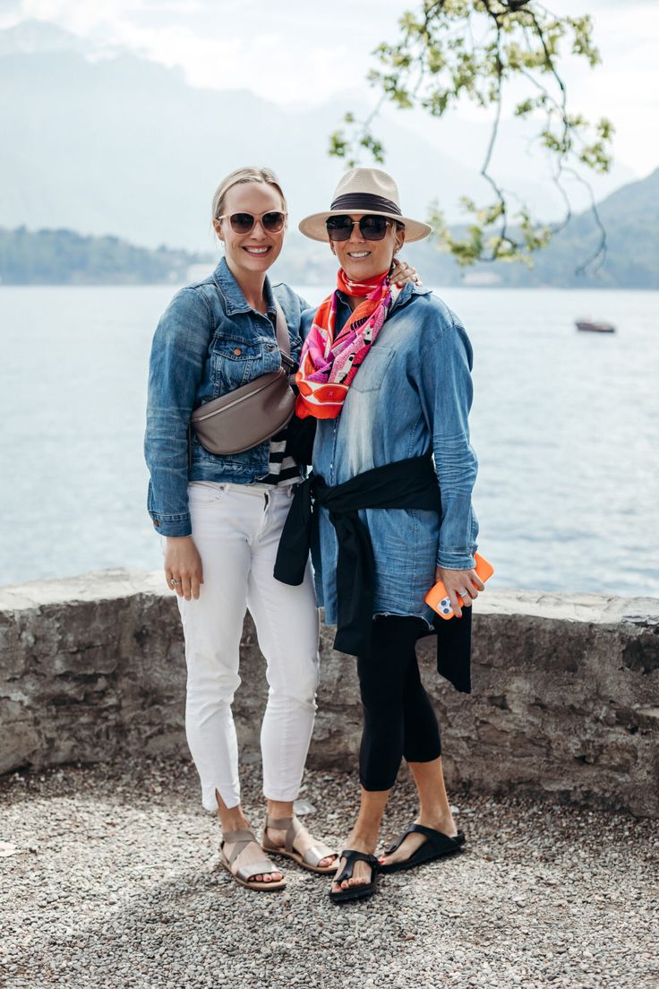 two women standing next to each other near the water