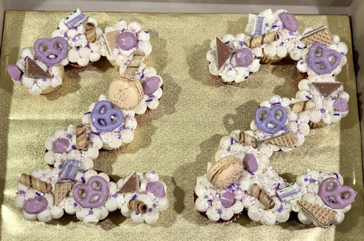 the letter e is made out of cupcakes and decorated with purple icing