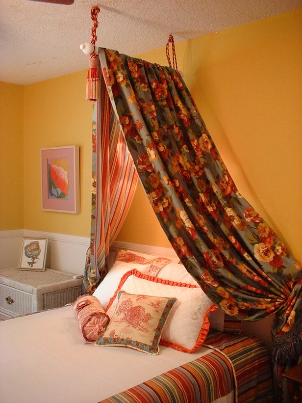 a canopy bed in a bedroom with yellow walls