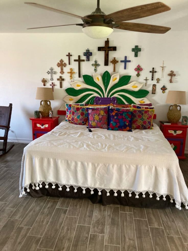 a large bed sitting in a bedroom under a ceiling fan