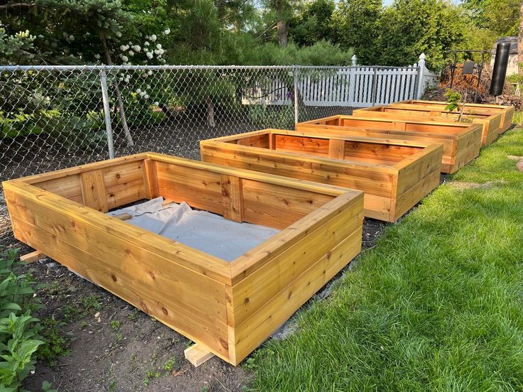 several wooden raised garden beds sitting in the grass