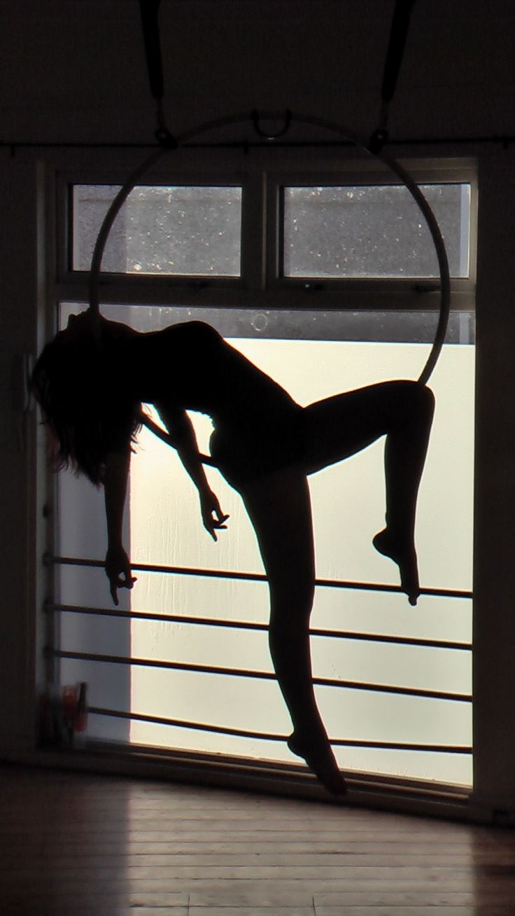 a woman doing a handstand in front of a window with the door open