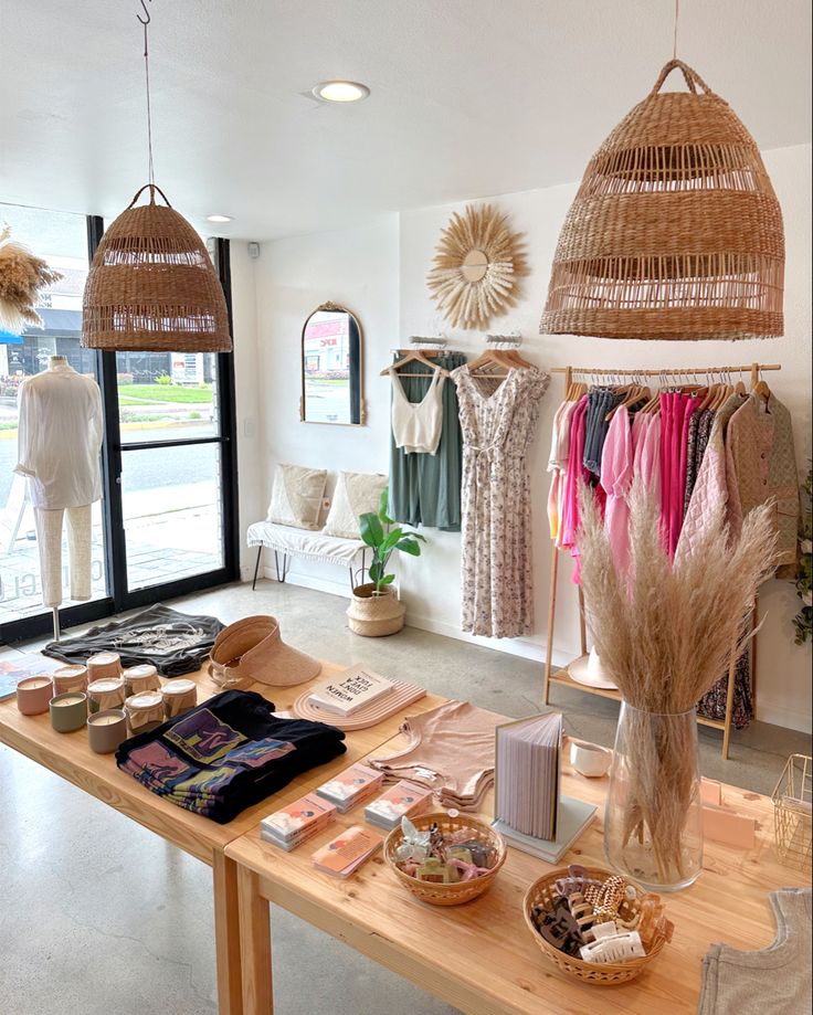 the inside of a clothing store with lots of items on tables and hanging baskets above them