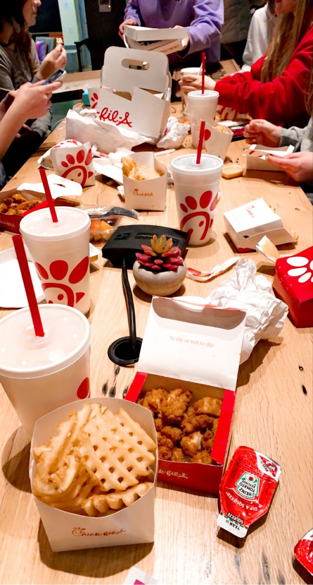 a group of people sitting at a table with food and drinks on it, including waffles