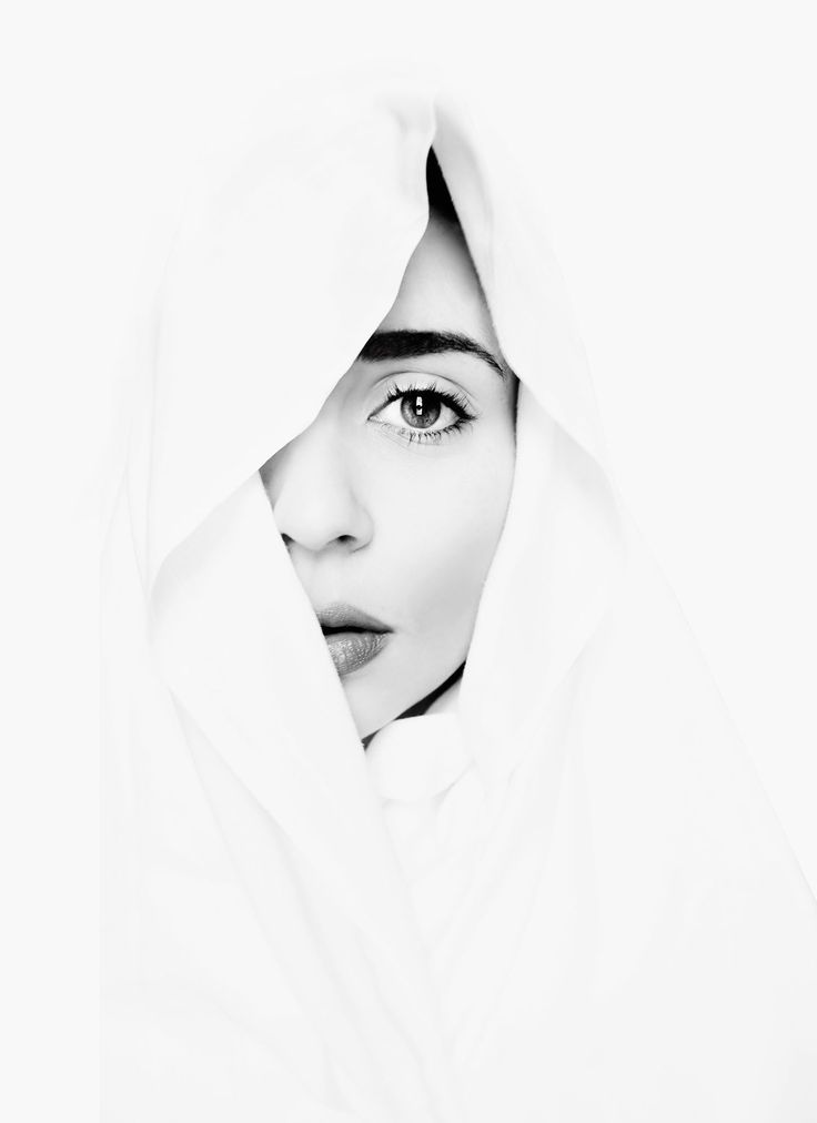 a black and white photo of a woman's face covered by a hoodie