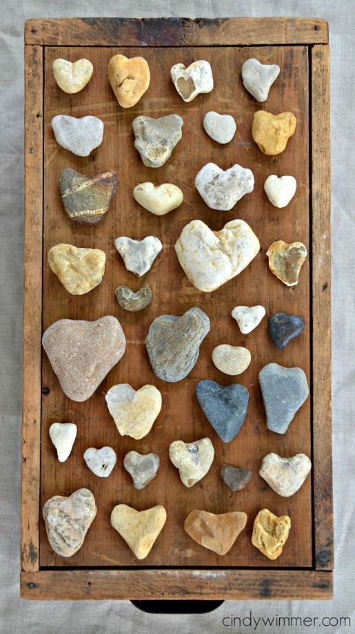 a wooden box filled with lots of heart shaped rocks