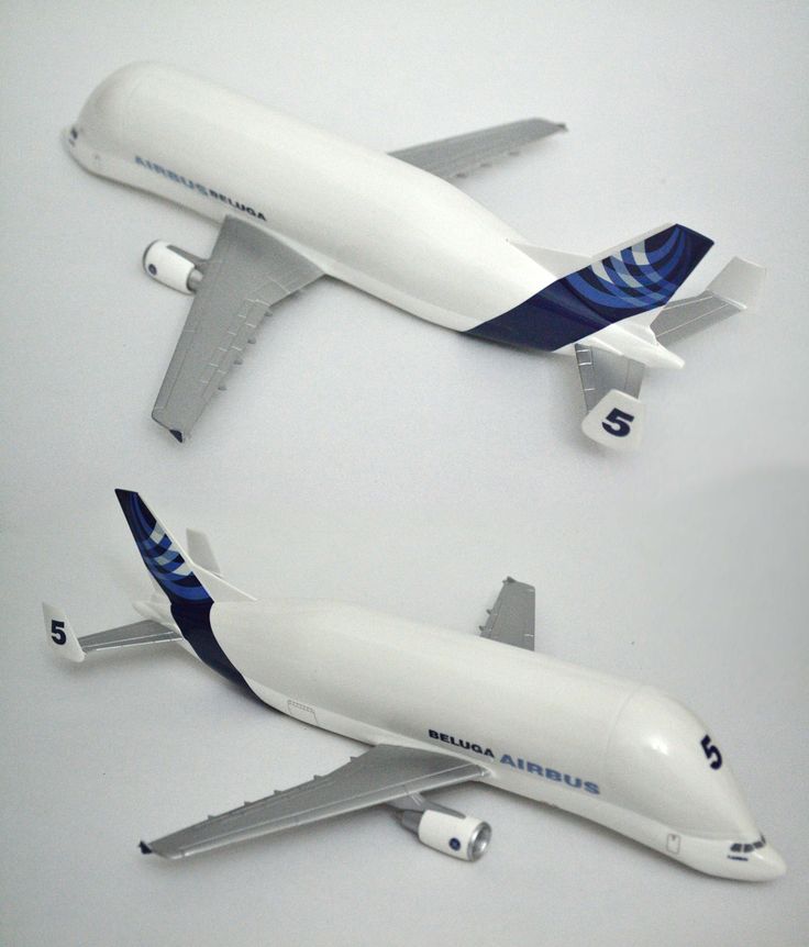 two model airplanes sitting on top of a white table next to each other, one is blue and the other is white